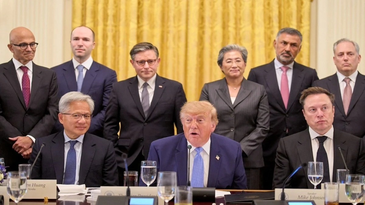 President Trump seated at the White House with Nvidia chief executive Jensen Huang and Elon Musk, with technology executives and officials standing behind