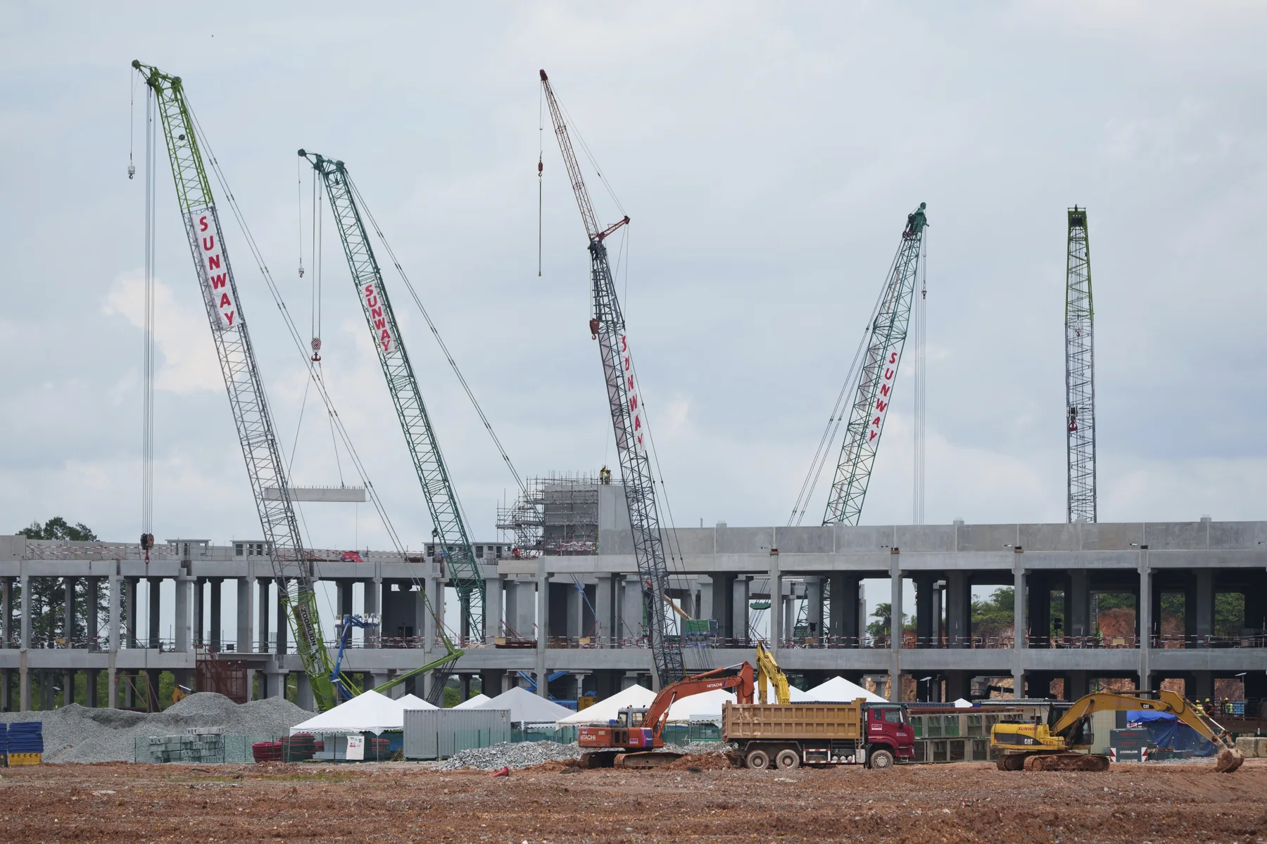A data centre building under construction at Sedenak Tech Park in Johor, Malaysia, with tower cranes on a wide cleared site